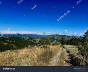 stock-photo-beautiful-utah-landscape-with-blue-skies-and-mountains-dirt-road-path-for-atv-2495711443